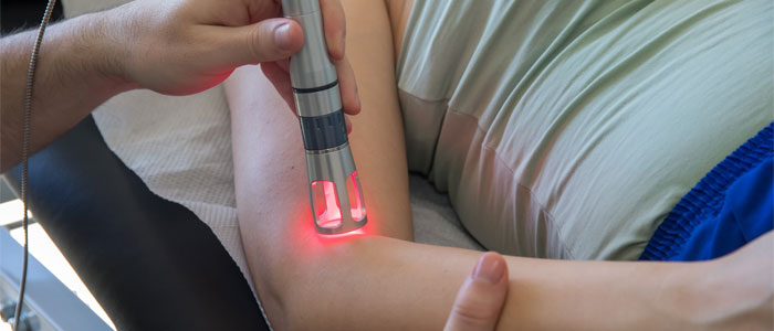 Person receiving laser therapy on their elbow